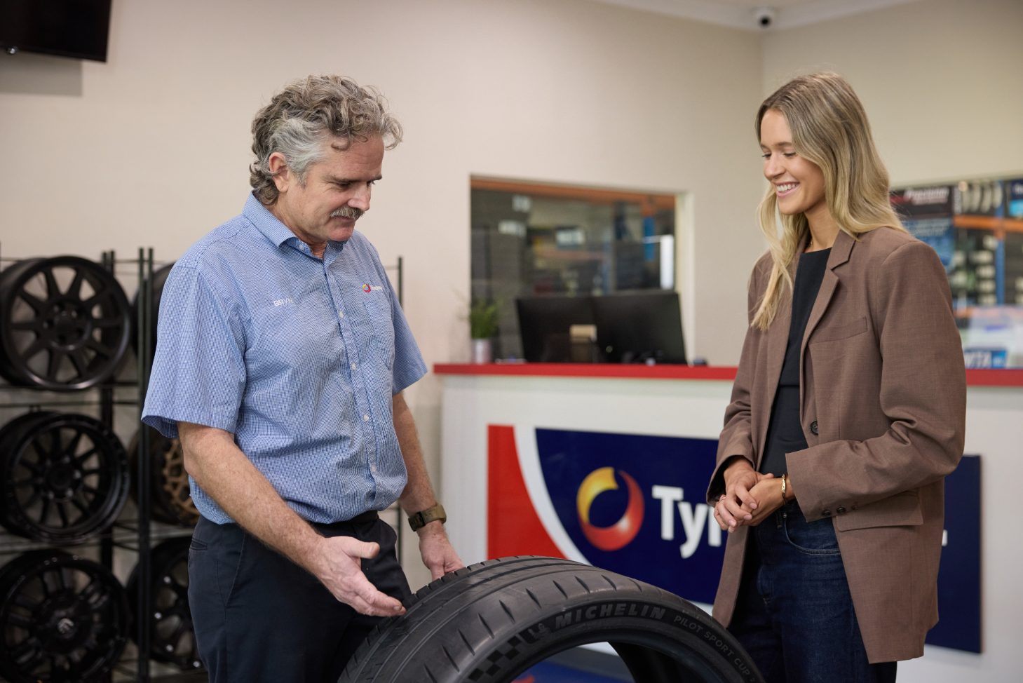 Customer choosing new tyres with staff at Tyrepower West Perth showroom near Leederville